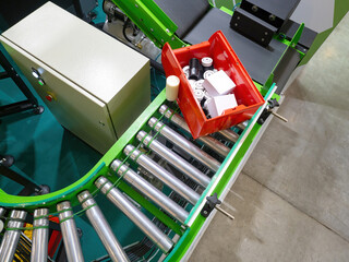 Poster - Manufacturing process. Red box on conveyor. Various spare parts in plastic container. Factory conveyor. Production conveyor top view. Concept of automated production.  processes without people
