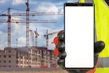 Poster - Construction apps. Mobile phone in builders hand. Apps for assistance builders concept. Smart phone in front of multi-storey building under construction. Construction of residential buildings