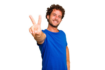 Wall Mural - Young caucasian curly hair man isolated Young caucasian man with curly hair isolated joyful and carefree showing a peace symbol with fingers.