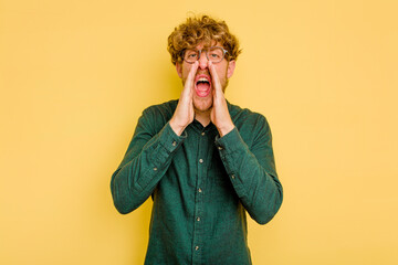 Young caucasian man isolated on yellow background shouting excited to front.