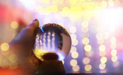 Poster - Crystal Ball on the floor with bokeh, lights behind. Glass ball with colorful bokeh light, celebration concept.