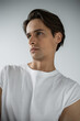 © LIGHTFIELD STUDIOS - portrait of brunette man in white t-shirt looking away isolated on grey