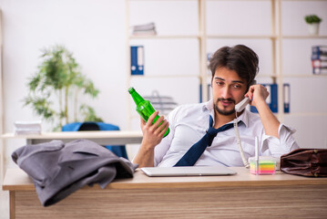 Poster - Young alcohol addicted employee sitting in the office