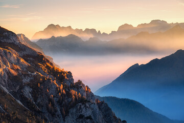 Wall Mural - mountains in low clouds at beautiful sunset in autumn in dolomites, italy. landscape with alpine mou