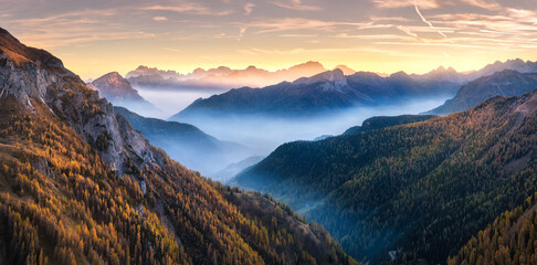 Wall Mural - mountains in low clouds at sunset in autumn in dolomites, italy. landscape with alpine mountain hill