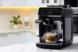 © New Africa - Modern coffee machine with glass cup of latte on white marble countertop in kitchen
