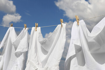 Clean clothes hanging on washing line against sky. Drying laundry