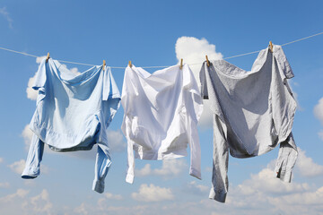 Clean clothes hanging on washing line against sky. Drying laundry