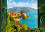 View through an open window with shutters looking down on the colorful picturesque village of Varenna, Italy, on the shores of Lake Como at summer.