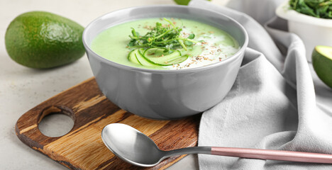 Bowl with green gazpacho on light background, closeup