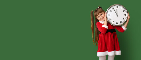 Sticker - Little girl in Santa costume holding clock on green background with space for text. Christmas countdown concept