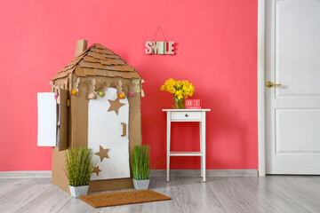 Poster - Interior of room with toy cardboard house in children's room