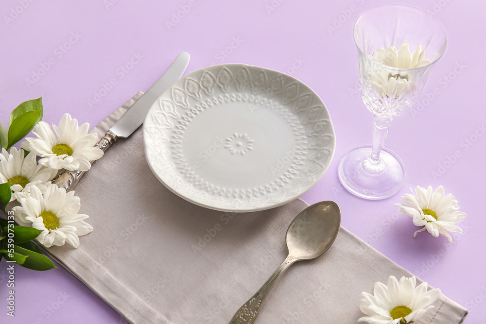 Simple table setting with white chamomile flowers on color background