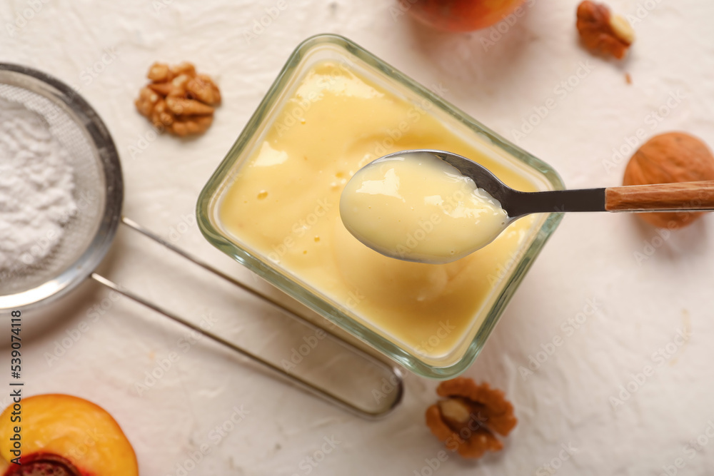 Glass bowl of delicious vanilla pudding on light background, closeup