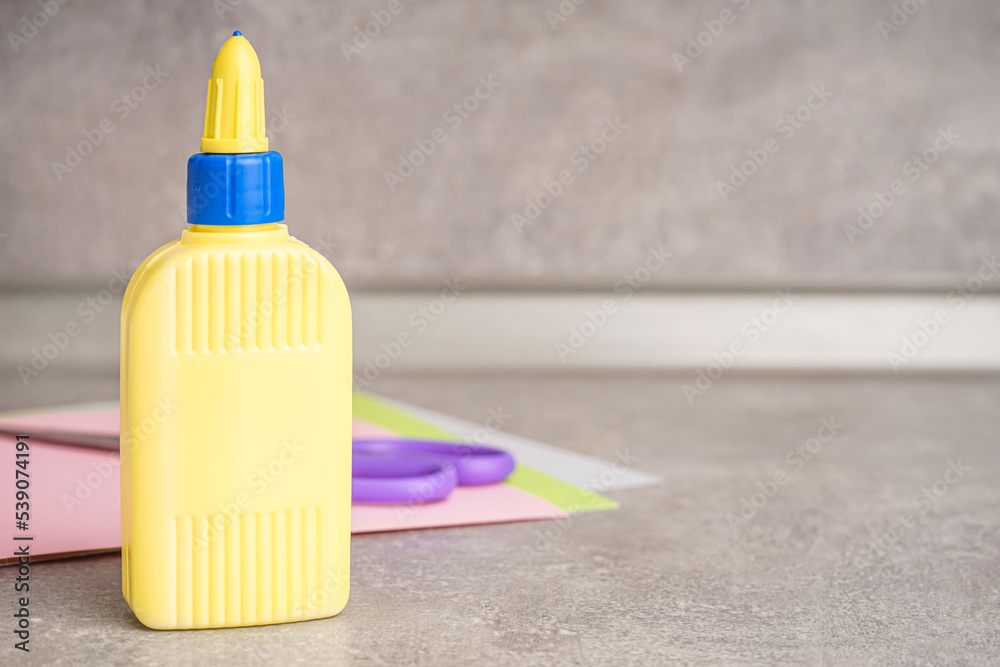 Bottle of glue on grunge background, closeup