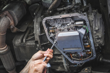auto mechanic installing an automatic transmission filter.