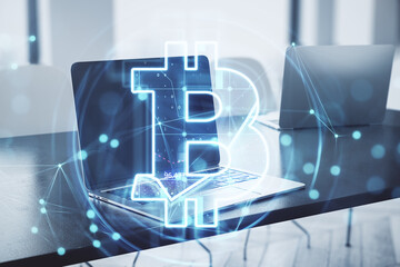 Fototapete - Close up of laptop with glowing bitcoin hologram on blurry office interior background. Metaverse, cryptocurrency and crypto concept. Double exposure.