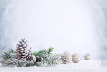 Christmas Still Life With Snowy Pine Cones, Baubles And  Fir Branches On Light Background. Winter Or Christmas Festive Concept.