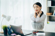 © Kritdanai - Portrait of smiling happy beautiful Asian woman relaxing using technology of laptop computer while sitting on table.Young creative girl working and typing on keyboard at cafe.work at home concept