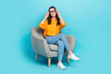 Poster - Full size portrait of cheerful gorgeous person sit chair hands touch glasses isolated on blue color background