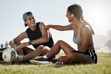 Fitness, friends and soccer grass break by man and woman relax, laugh and enjoy conversation on a soccer field. Wellness, couple and cheerful interracial lady and guy bonding after football training