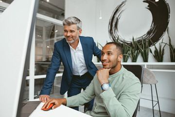 Two multiethnic business colleagues working together in modern office