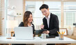 © wattana - Smiling businessman negotiating about business project with female coworker.