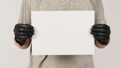 Wall Mural - Hands are holding the A4 paper and wearing latex gloves with gray t-shirt on white background.Body part