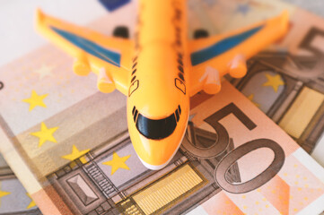 Airplane on the background of cash euros. The cost of the flight, the price of plane tickets. Selective focus.