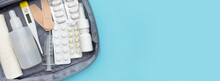 Banner With A Set Of Medicines And Pills In A First Aid Kit. Place For Text. Copy Space. Top View. Flat Lay. Blue Background.