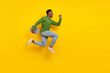 © deagreez - Full length body size view of handsome trendy guy jumping carrying laptop rejoicing isolated over vivid yellow color background