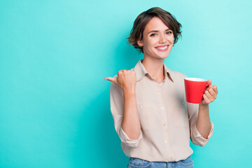 Sticker - Photo of cheerful adorable lady office worker arm direct empty space nice proposition enjoy hot tasty tea isolated on cyan color background