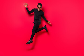 Wall Mural - Full length body size view of attractive trendy cheerful guy jumping dancing rest isolated over bright red color background