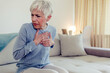 © Jelena Stanojkovic - Upset stressed mature middle aged woman feeling pain ache touching chest having heart attack. Sad worried senior older lady suffers from heartache at home, infarction or female heart disease concept.