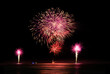 © Austockphoto - Multi coloured fireworks exploding over an ocean in the night sky.