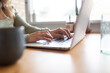 © Austockphoto - close up shot of a woman's hand on the laptop keyboard on a wooden table
