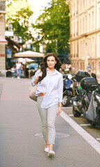 Wall Mural - Outdoor portrait of beautiful young woman walking down the street, wearing backpack, city background