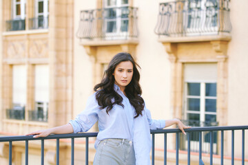 Wall Mural - Fashion portrait of beautiful young woman, wearing blue shirt, posing outdoors