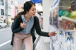 © PR Image Factory - Korean girl customer turning the handle of gashapon vending machine for capsule toys at a play station in shinsaibashisuji and doutonbori Osaka japan