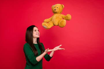 Sticker - Photo of cute brunette lady catch toy wear green shirt isolated on red color background