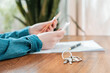 Close up of key with keychain lies on the table. Defocused female's hands counting money at the background. Concept of purchase of real estate, leasing and mortgage
