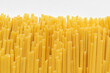 Uncooked durum fettuccine pasta on white background. Raw spaghetti or noodles