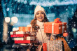 © ivanko80 - Christmas shopping.Woman holding shopping bags in a snowy night.