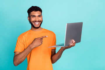 Photo of positive person toothy smile indicate finger wireless netbook isolated on aquamarine color background