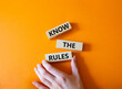 Know the rules symbol. Wooden blocks with words Know the rules. Beautiful orange background. Businessman hand. Business and Know the rules concept. Copy space.