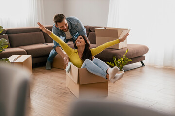 Happy couple is having fun with cardboard boxes