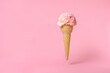 summer funny creative concept of flying wafer cone scoops of ice cream decorated with strewed sprinkles on pink background