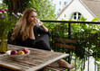© rubchikova - Young woman is sitting on a terrace and drinking coffee