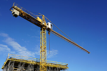 Canvas Print - Yellow construction crane and concrete formworks structure in new modern building construction site