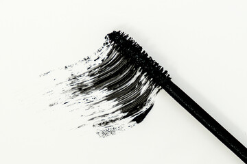 smudged mascara texture, swatch of a brush on white background